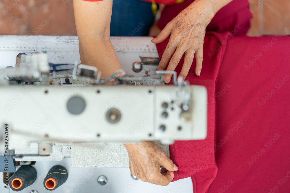 Top view of the hands of a woman working with a sewing machine