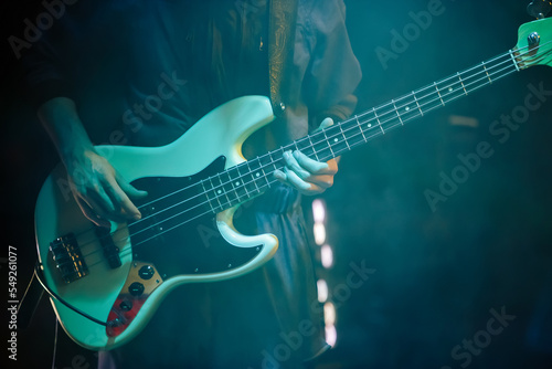 Bass guitarist plays solo part on rock concert. Professional guitar player performing live on stage