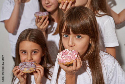 Partial of children eat sweet delicious doughnuts