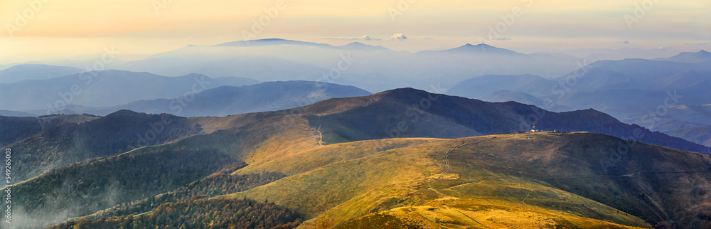 Autumn landscape, panorama, banner - view of the mountains covered with montane meadows and forests under the autumn sun in the Carpathians, Ukraine