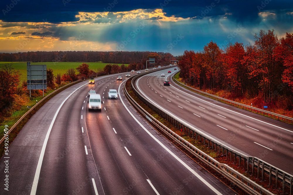 Fototapeta premium Langzeitbelichtung - Autobahn - Strasse - Traffic - Travel - Background - Line - Ecology - Highway - Night Traffic - Long Exposure - Cars Speeding - Lights - Sunset - High quality photo