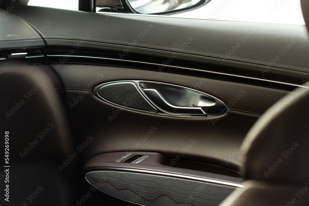 Modern car interior door handle close up. Metallic Car door opener handle inside.