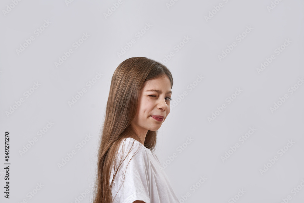 Side view of winking little girl looking at camera Side view of winking little girl looking at camera