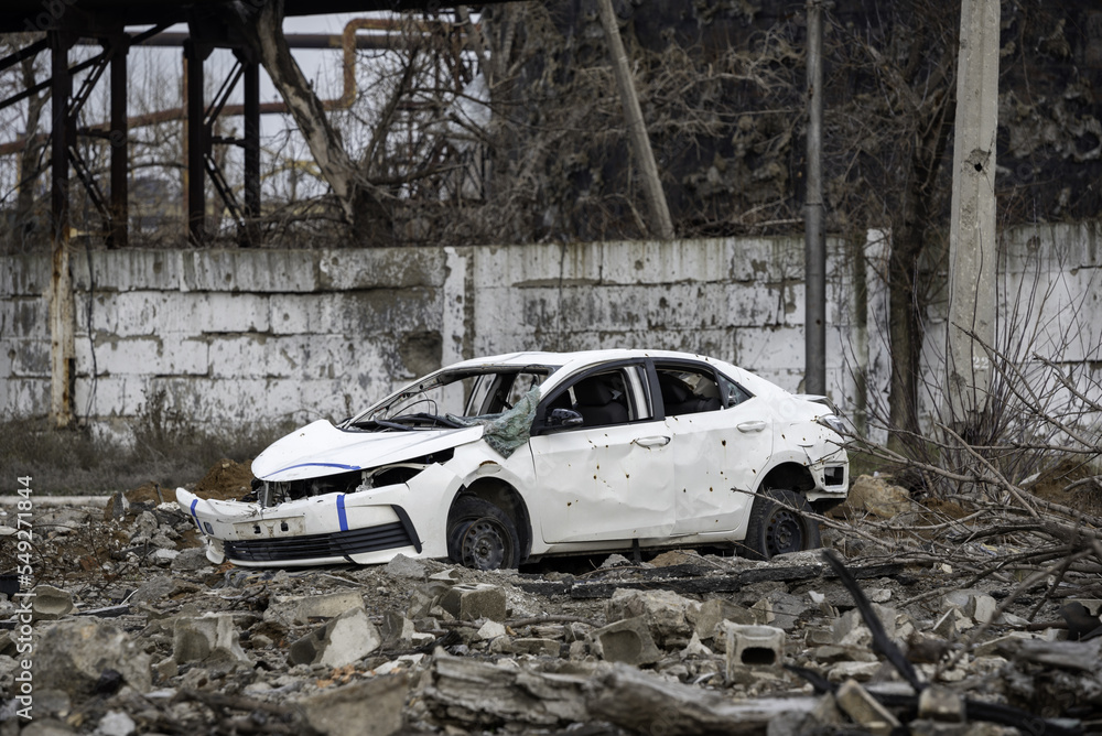 car and destroyed buildings of the workshop of the Azovstal plant in Mariupol