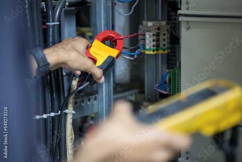 Canvas Print An engineer is using a clamp meter to measure an electric current