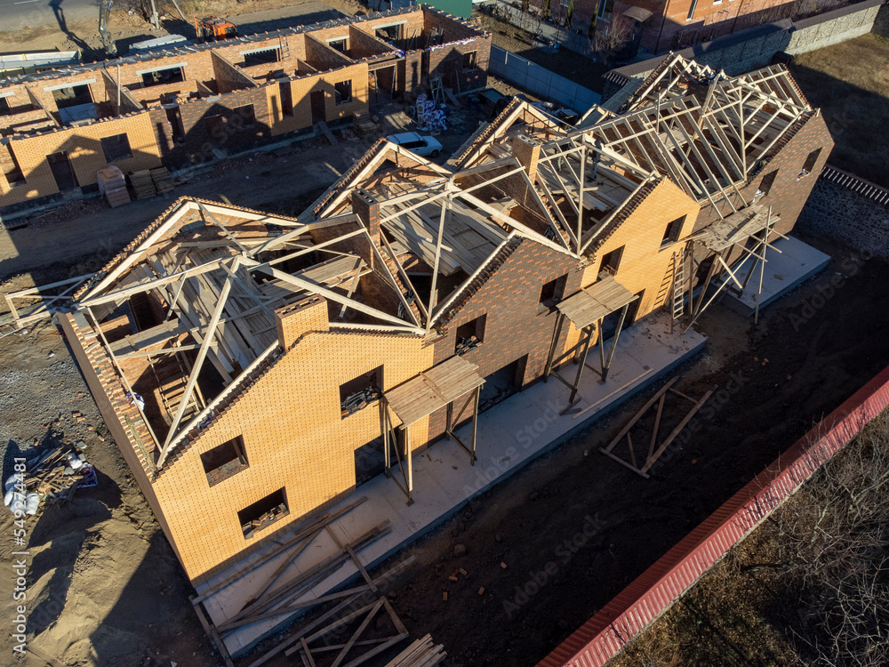 Aerial view of roof construction repairman on a residential apartment with new roof shingle being applied Aerial view of roof construction repairman on a residential apartment with new roof shingle being applied