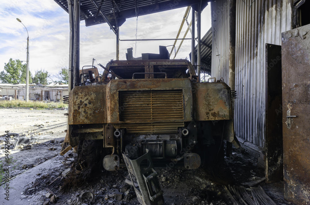 burnt military armored car on the street of the ruined city