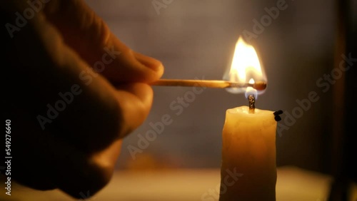 closeup man lighting a candle with a match