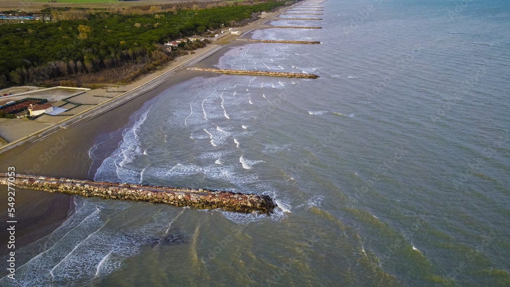 Aerial shot of Eraclea beach with sand, waves and stones, Veneto Aerial shot of Eraclea beach with sand, waves and stones, Veneto