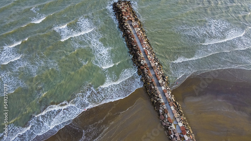 Aerial shot of Eraclea beach with sand, waves and stones, Veneto photo