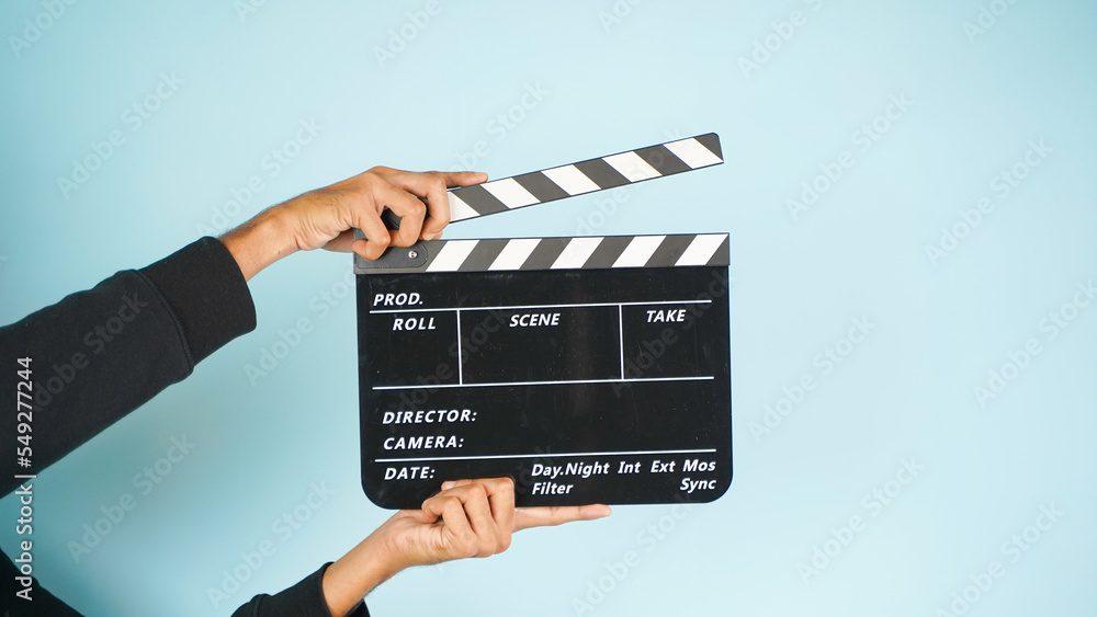 Hand is holding clapper board or clapperboard or movie slate, used in film production and cinema ,movies industry isolated over color background.