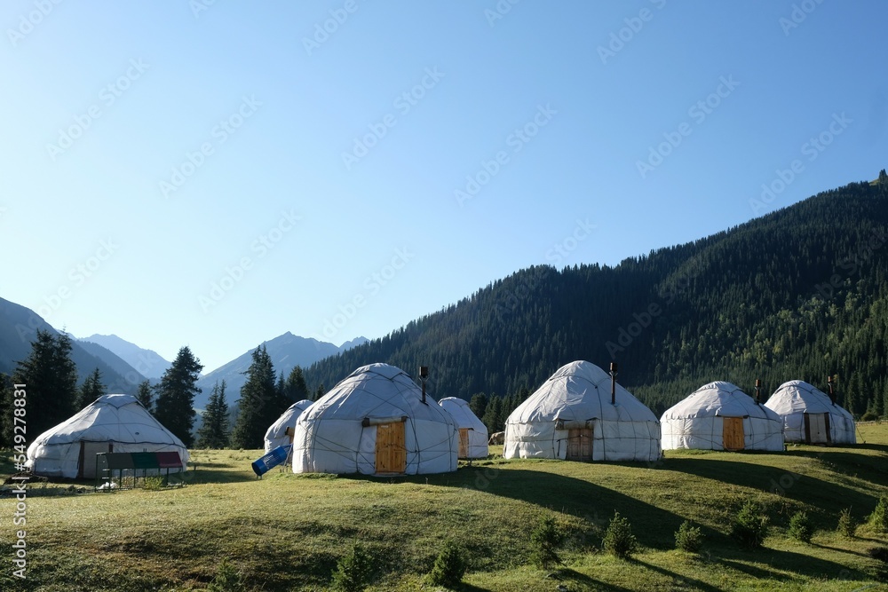 Yurt camp in Karakol Mountains, Tien Shan Mountains, Kyrgyzstan, Central Asia. Traditional nomad's yurts on green mountain meadow in summer. 