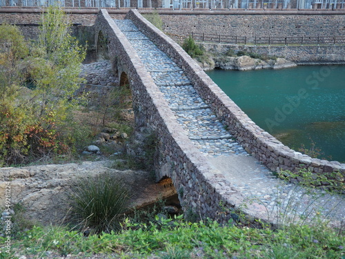puente medieval con tres ojos y calzada empedrada situado sobre el ría noguera ribagorzana, sopeira, huesca, españa, europa photo