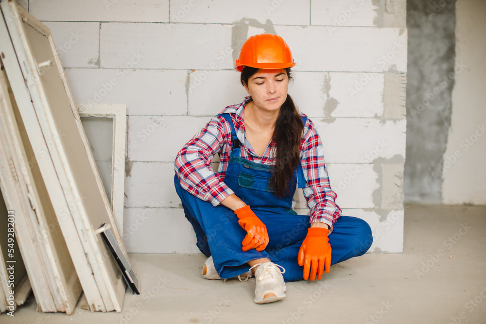 tired worker sit on concrete floor after hard work. women's work in men's  professions and equality foto de Stock | Adobe Stock