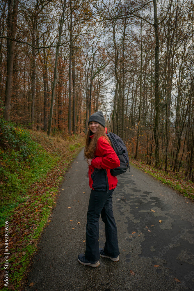 young tourist woman with backpack in an autumnal forest. A single independent courageous and happy woman. young tourist woman with backpack in an autumnal forest. A single independent courageous and happy woman.