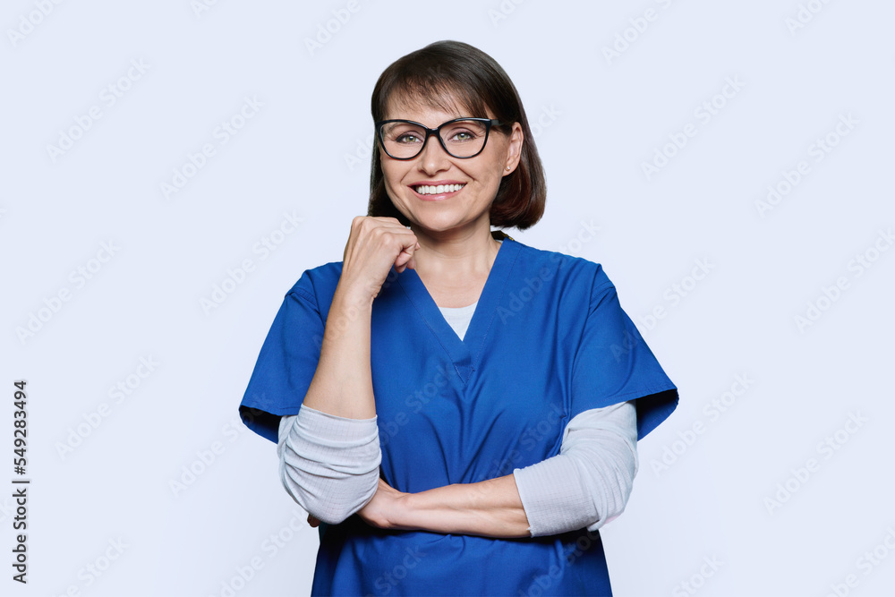 Portrait of middle aged nurse in uniform looking at camera on white background Portrait of middle aged nurse in uniform looking at camera on white background