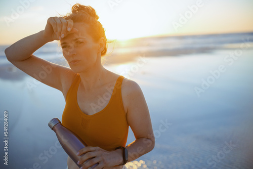 Obraz na plátně tired healthy sports woman at beach in evening
