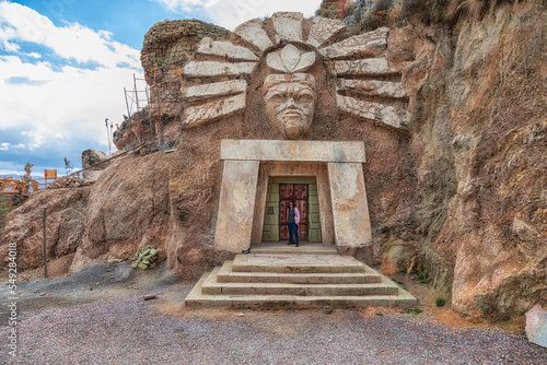 Cusco, Peru - September 24, 2022: La Morada De Los Dioses - Apukunaq Tianan (the abode of the gods), a tourist attraction in Cusco. Here a tourist in the entrance of the temple of the sun god. photo