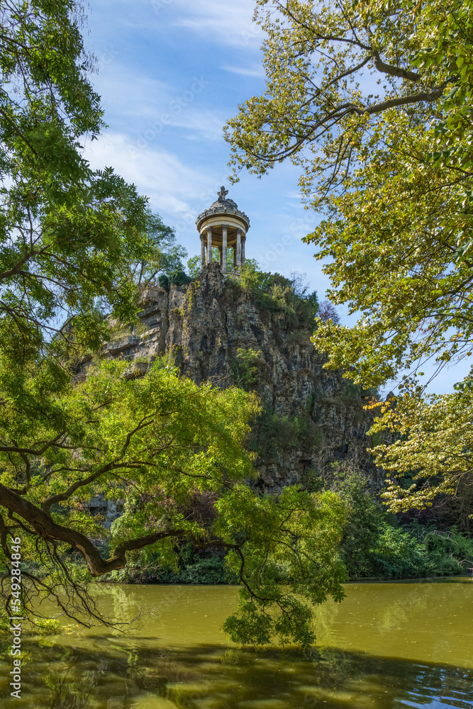 Sibyl temple on the hill and lake in Buttes Chaumont Park, Paris, France.