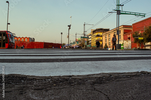 cruce paso de cebra en calle de México en la ciudad de mexico centro histórico en atardecer transporte publico espera el paso color rojo cultura de un día en atardecer cinematográfico photo