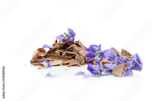 Wiórki czekolady o smaku fiołkowym z kawałkami kwiatów fiołków.