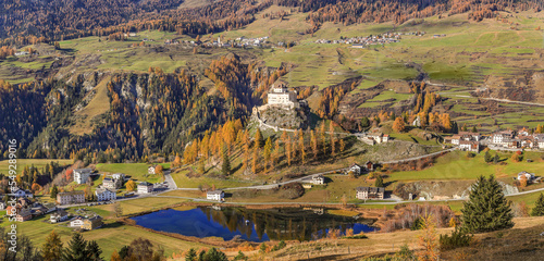 Scoul, Siwtzerland - October 30. 2022: Panorama of the valley with the Tarasp Castle in autumn splendid color from a high view photo