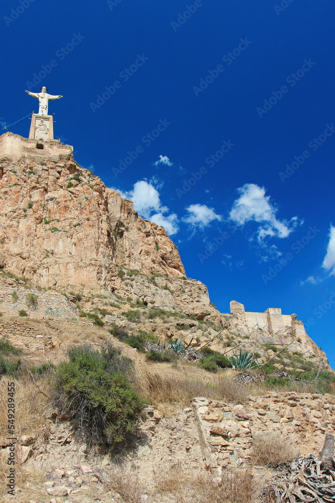 Castle of Monteagudo on the very top of the limestone rock with a statue of Jesus Christ