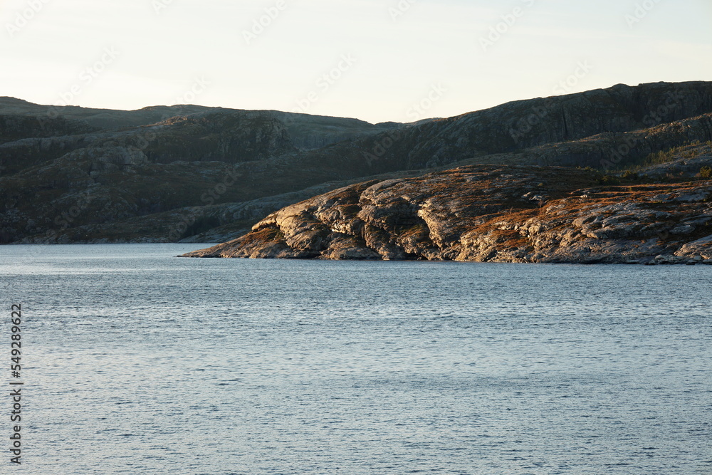 Blick über das Meer auf die steinige Küste von Norwegen