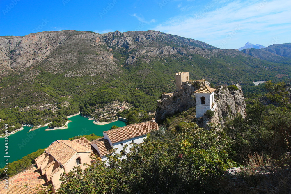 Guadalest castle on the topmost part of the cliff with castle buildings and a mountain lake