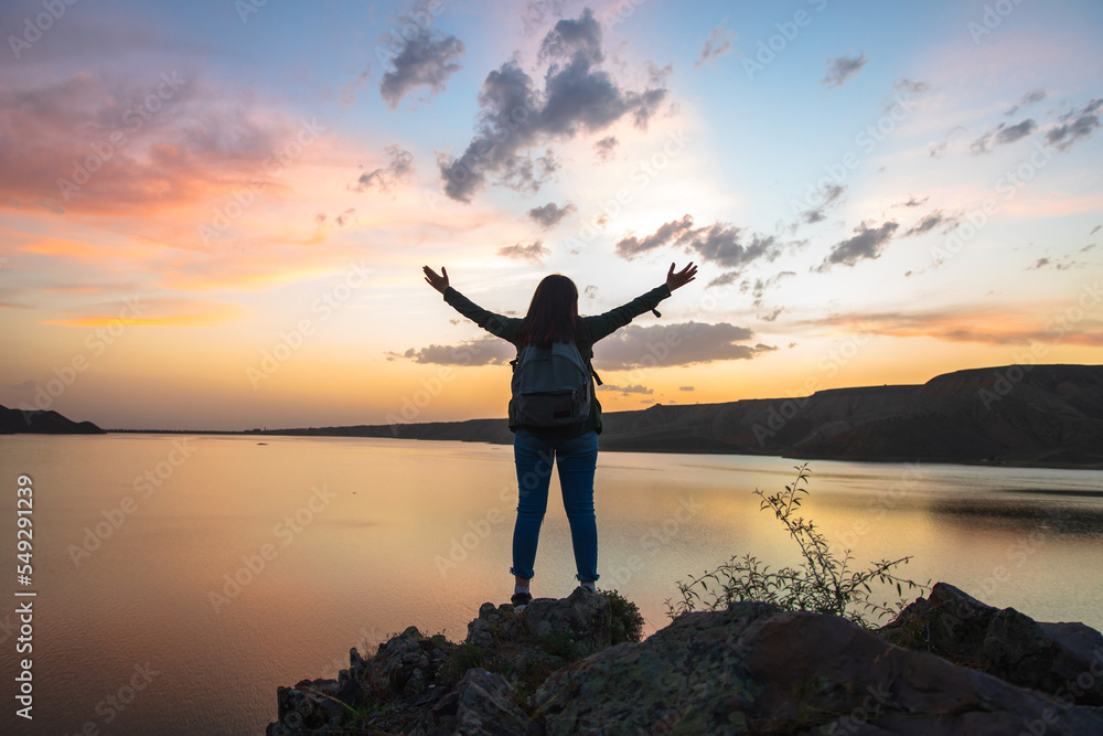 Fototapeta premium Woman standing by the lake with open arms