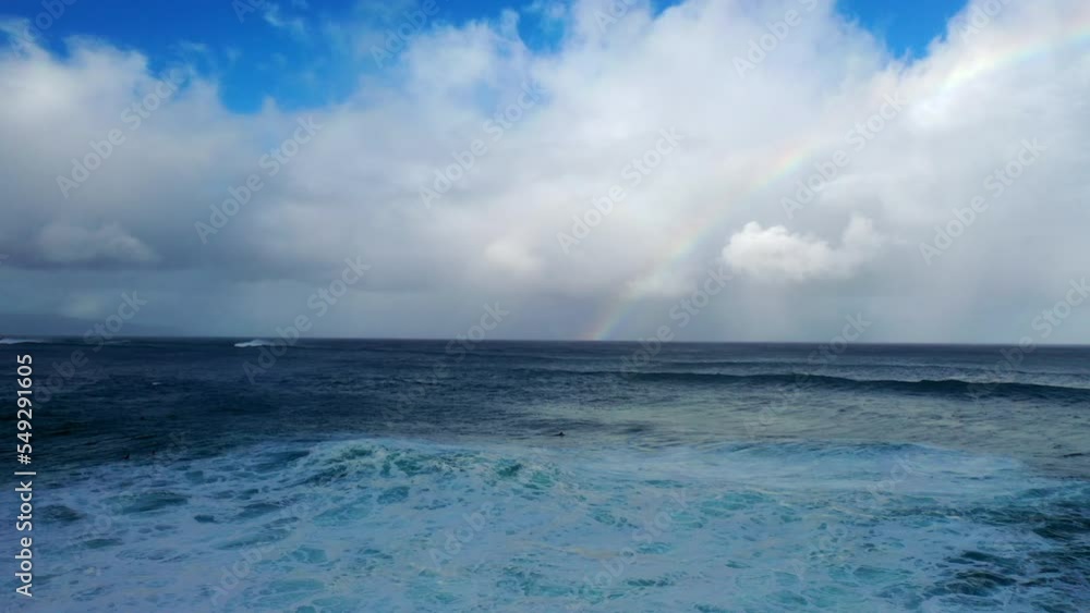 Aerial Scenic Shot Of Rainbow In Fluffy Clouds, Drone Flying Forward Over Wavy Sea - Waikiki, Hawaii Aerial Scenic Shot Of Rainbow In Fluffy Clouds, Drone Flying Forward Over Wavy Sea - Waikiki, Hawaii