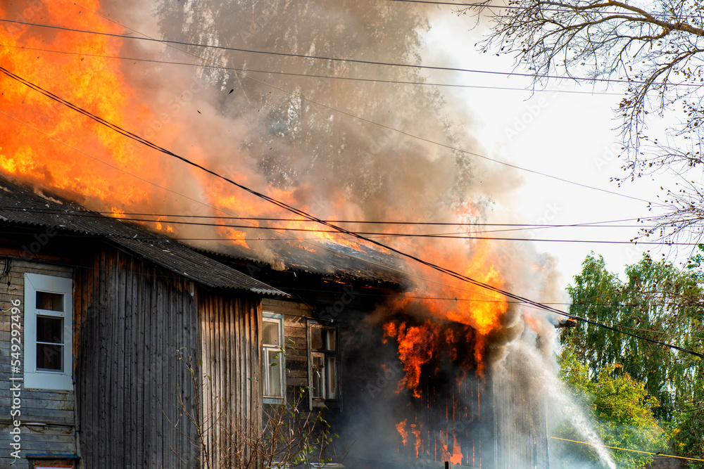Fire quickly destroys residential building. Firefighters trying to put out big fire. - obrazy, fototapety, plakaty 