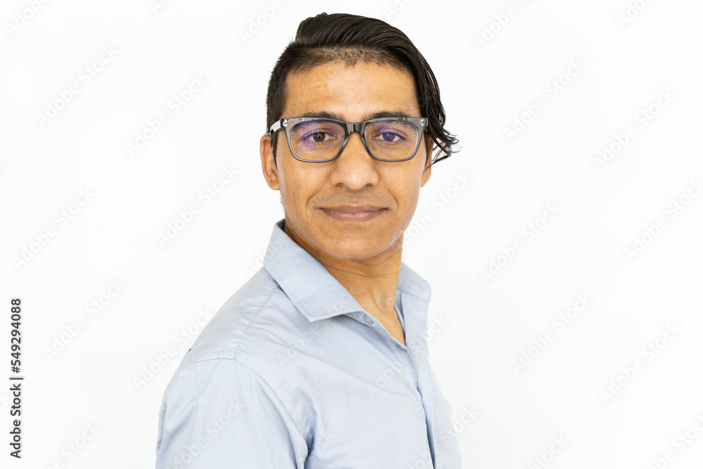 Serious man looking at camera. Indian man in blue shirt and glasses with confident expression. Portrait, studio shot, confidence concept