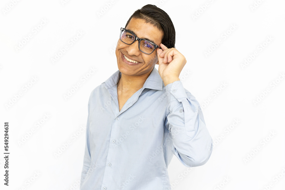 Joyful man touching glasses. Indian man in blue shirt looking at camera and smiling. Portrait, studio shot, joy concept Joyful man touching glasses. Indian man in blue shirt looking at camera and smiling. Portrait, studio shot, joy concept
