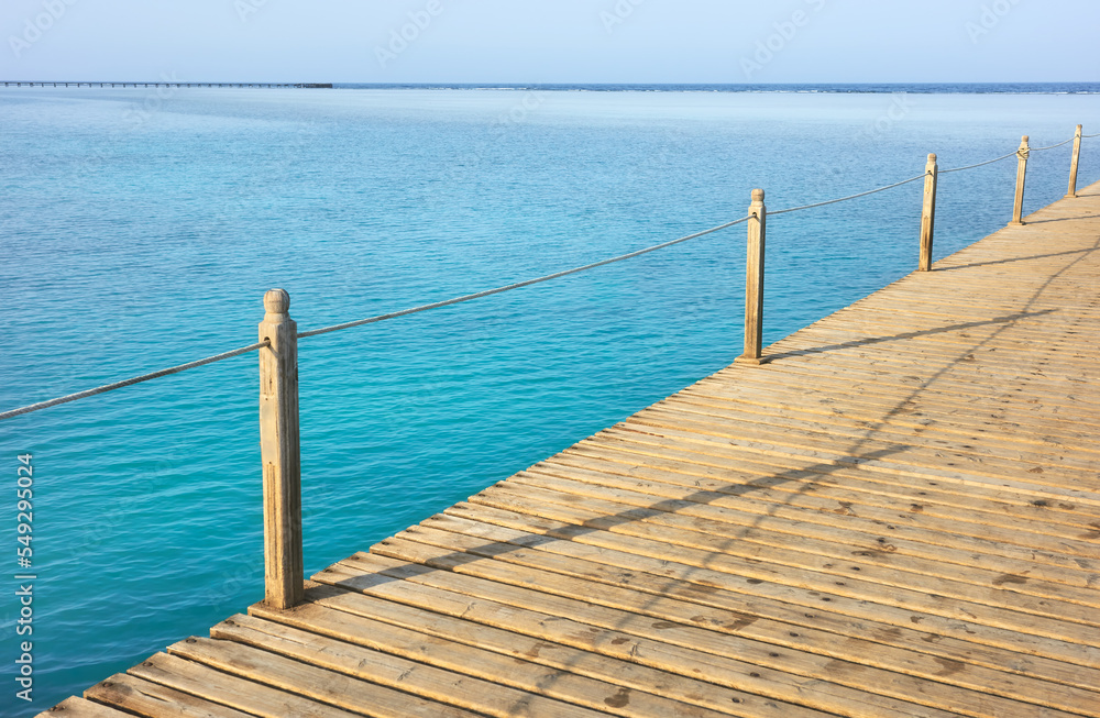 Fototapeta premium Wooden pier with rope railing, selective focus.