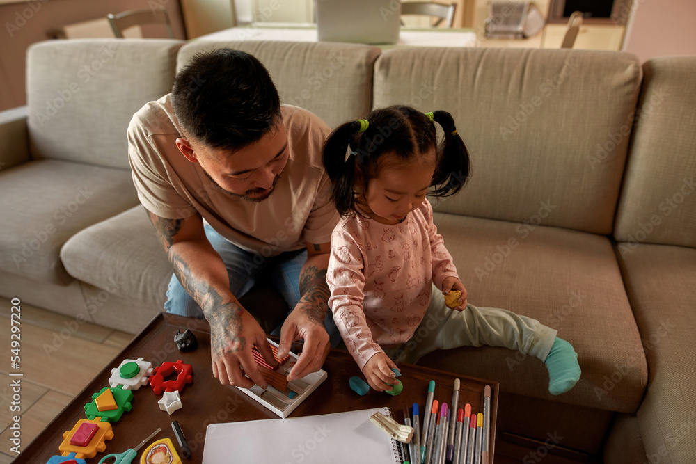 Fototapeta premium Asian father and daughter sculpt with plasticine