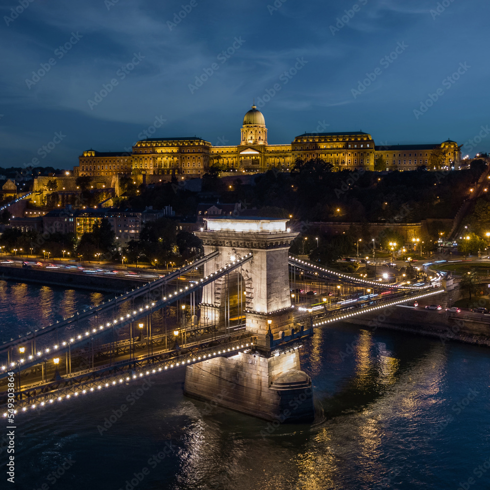 Aerial view of historic landmark Szechenyi Chain Bridge over the Danube river at dusk in Budapest, Hungary. 