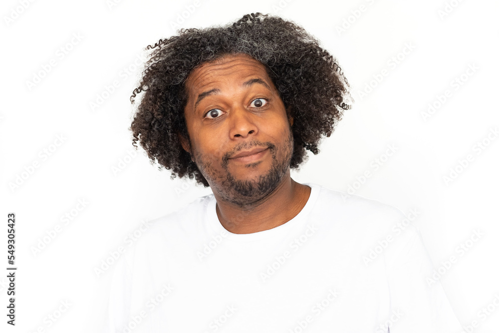 Portrait of amused African American man. Surprised mature male model with dark curly hair in white T-shirt looking at camera, smiling, seeing something unusual. Shock, advertisement concept Portrait of amused African American man. Surprised mature male model with dark curly hair in white T-shirt looking at camera, smiling, seeing something unusual. Shock, advertisement concept