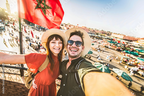 Happy tourists couple visiting Jamaa el-Fna market Marrakech, Morocco - Boyfriend and girlfriend taking selfie picture on summer vacation - Holidays and tourism concept photo
