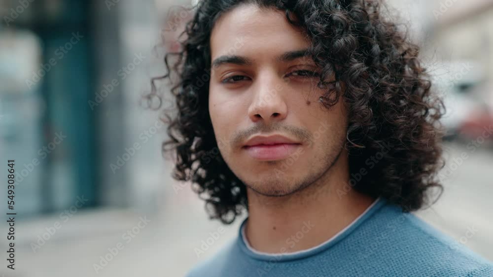 Young latin man standing with serious expression at street Young latin man standing with serious expression at street