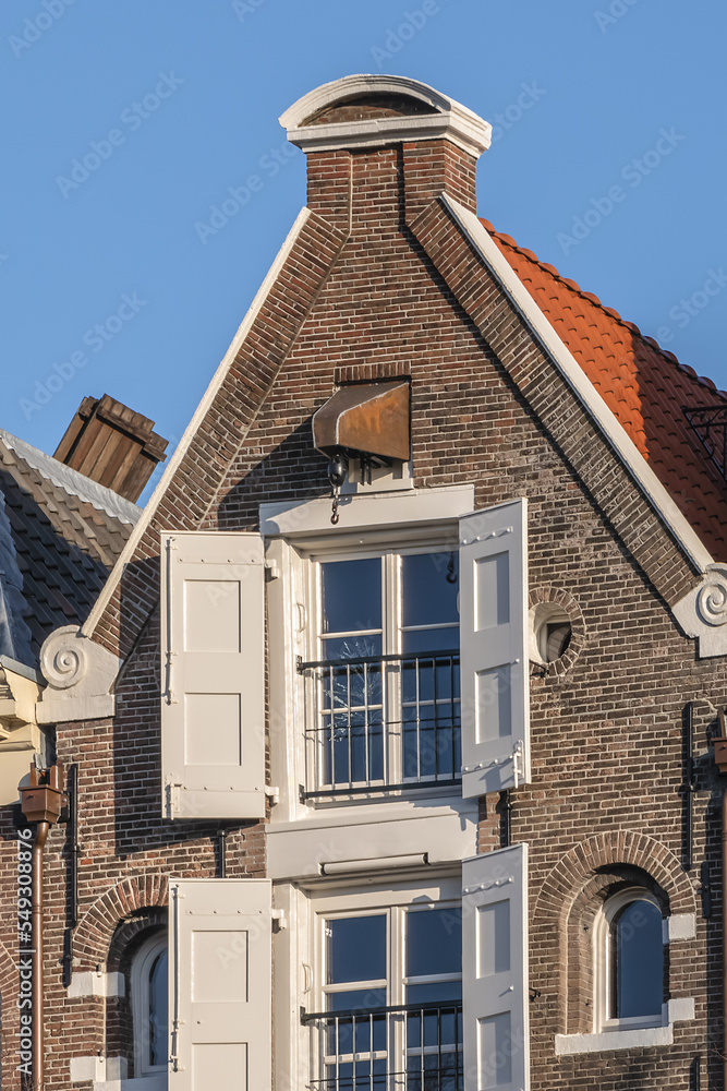Close-up colorful old buildings with gable rooftops and hooks along Keizersgracht canal in Amsterdam. Keizersgracht (Emperor’s Canal, 1612) named after Emperor of Austria. Amsterdam, the Netherlands. Close-up colorful old buildings with gable rooftops and hooks along Keizersgracht canal in Amsterdam. Keizersgracht (Emperor’s Canal, 1612) named after Emperor of Austria. Amsterdam, the Netherlands.