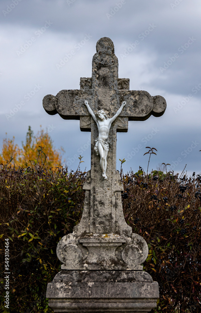 Crucifix on the background of an autumn hedge