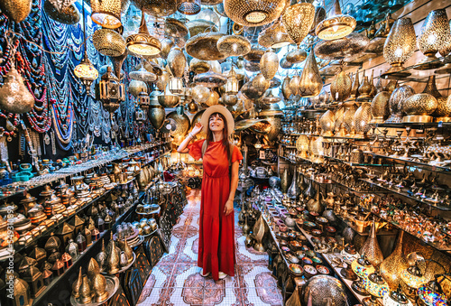 Young traveling woman visiting a copper souvenir handicraft shop in Marrakesh, Morocco - Travel lifestyle concept photo