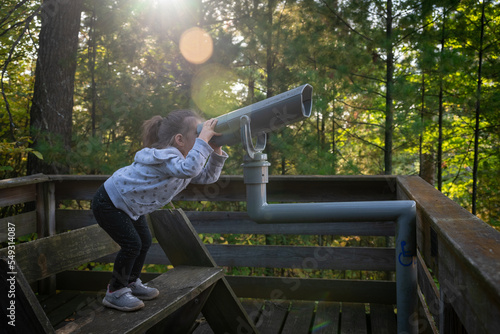 girl with a telescope in a forest in Wisconsin photo