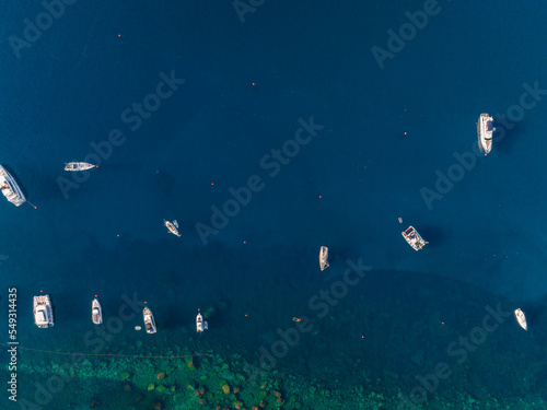 High angle view of motorboat moving by luxurious yacht. Nautical vessels at beautiful Mediterranean seascape. Idyllic view of blue ocean at Italian coast.