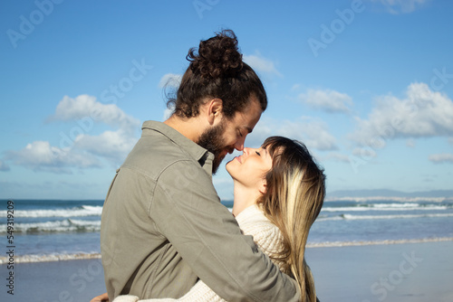 Caucasian couple on summer vacation. Bearded man and woman with fair hair looking at each other, touching with noses tenderly. Love, vacation, affection concept © KAMPUS