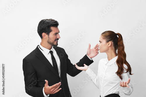 Man and woman anger business in business at each other shouting with their hands up in the air against a white isolated background. The concept of business in a couple harassment startup copy space