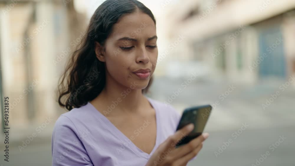 Young african american woman talking on smartphone with worried expression at street Young african american woman talking on smartphone with worried expression at street