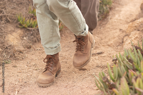 Close-up of female hiking boots. Hiking boots of traveler standing on dry sand. Sport, adventure, travelling concept
