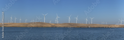 Wind turbines renewable energy off the water in Rio Vista Ca. on a clear day      
